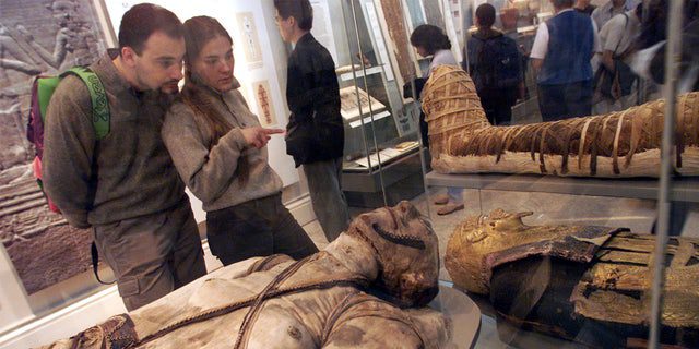 Los visitantes ven algunas momias egipcias en el Museo Británico de Londres.