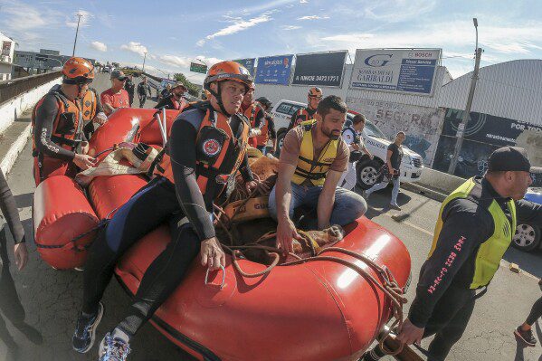 Los bomberos utilizan una balsa para transportar un caballo después de que fue rescatado del techo, donde había estado atrapado durante días en las inundaciones, después de las fuertes lluvias en Canoas, estado de Rio Grande do Sul, Brasil, el jueves 9 de mayo de 2024. (Foto AP /Wesley Santos)