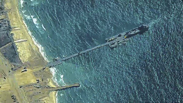 La fotografía, proporcionada por el Comando Central de los EE. UU., muestra a los soldados del ejército de los EE. UU. asignados a la 7.ª Brigada de Transporte (expedicionaria), a los marineros de la Armada de los EE. UU. asignados al Batallón de Construcción Anfibio 1 y a las Fuerzas de Defensa de Israel colocando el muelle Trident en la costa de la Franja de Gaza el Jueves.  16 de mayo de 2024. El muelle temporal forma parte de la capacidad logística conjunta sobre la playa.  El ejército estadounidense terminó de instalar el muelle flotante el jueves, mientras los funcionarios se preparaban para comenzar a transportar ayuda humanitaria muy necesaria a la Franja, que ha sido asediada por siete meses de intensos combates en la guerra entre Israel y Hamás.  (Comando Central de EE. UU. vía AP)