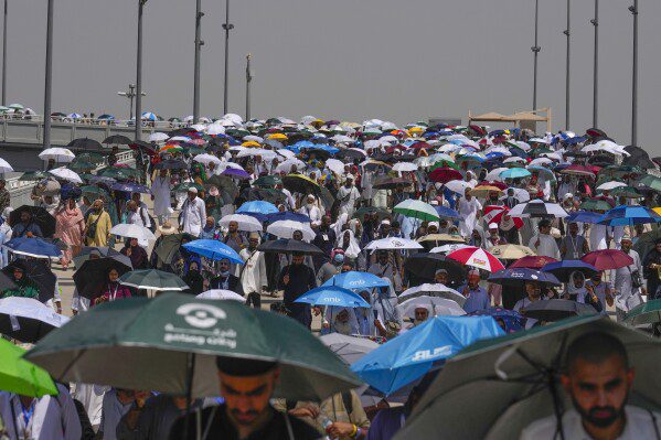 ARCHIVO - Los peregrinos musulmanes usan paraguas para protegerse del sol cuando llegan para arrojar piedras a los pilares en la lapidación simbólica del diablo, el último ritual del Hajj anual, en Mina, cerca de la ciudad santa de La Meca, Arabia Saudita, el martes. , 18 de junio de 2024. Domingo 23 de junio de 2024 Más de 1.000 personas murieron durante la temporada del Hajj de este año en Arabia Saudita mientras los creyentes enfrentaban temperaturas extremadamente altas en los lugares sagrados islámicos del reino del desierto.  (Foto AP/Rafiq Maqbool)