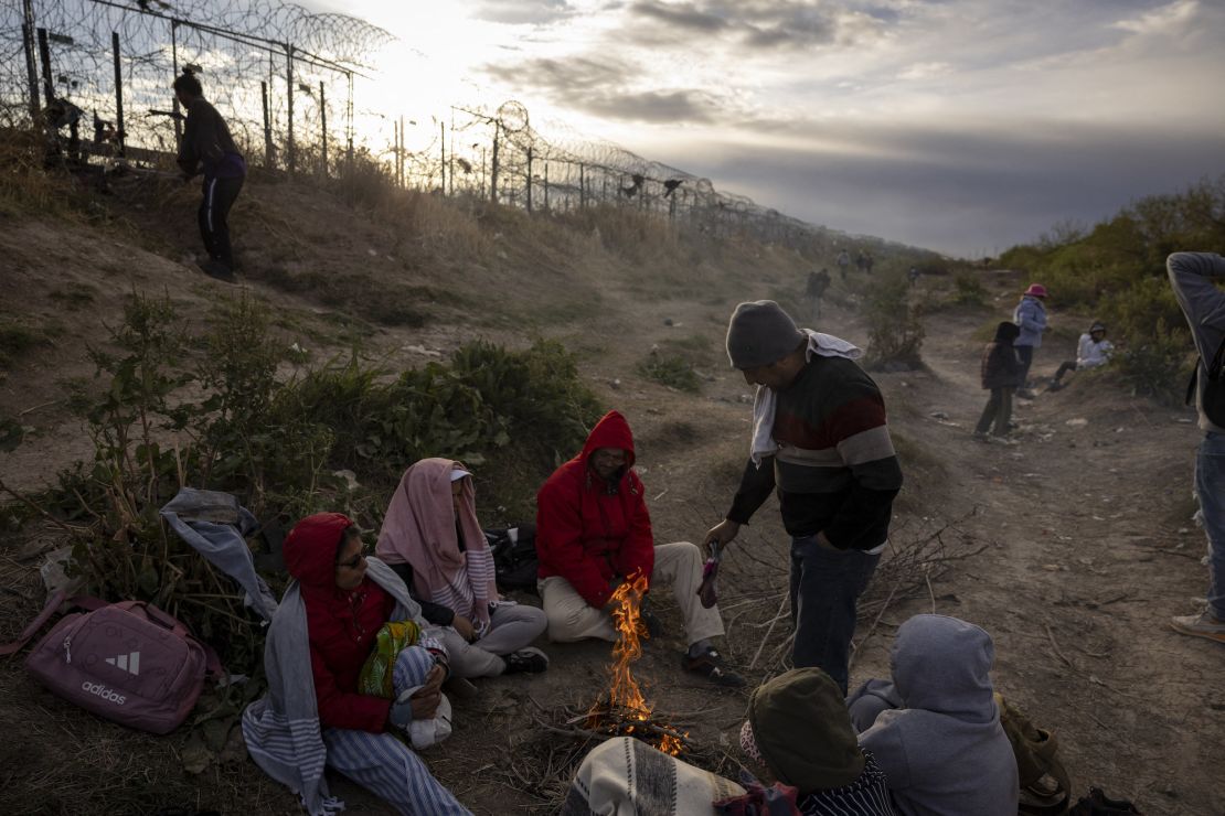 Migrantes venezolanos se sientan junto a un fuego improvisado mientras esperan entrar y buscar asilo en El Paso, Texas, procedentes de Ciudad Juárez, Chihuahua, México, el 2 de abril de 2024.